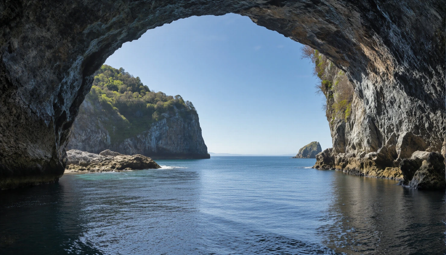 Coastal Cave Entrance Opening to the Sea under a Clear Blue Sky #40092