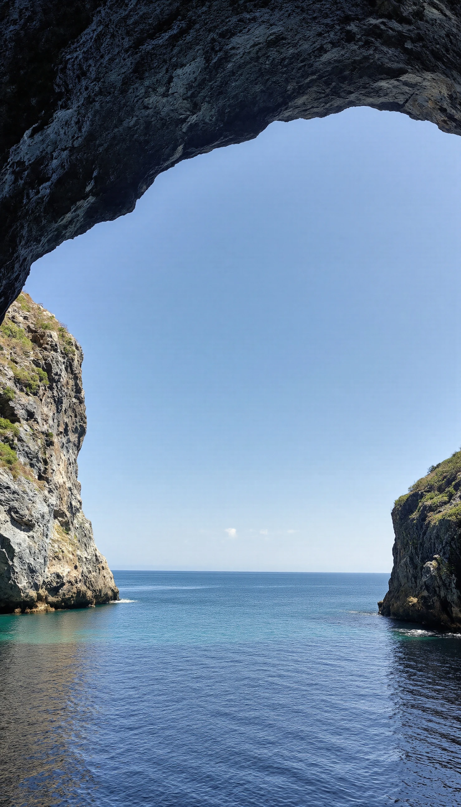 Coastal Cave Entrance Opening to the Sea under a Clear Blue Sky #40093