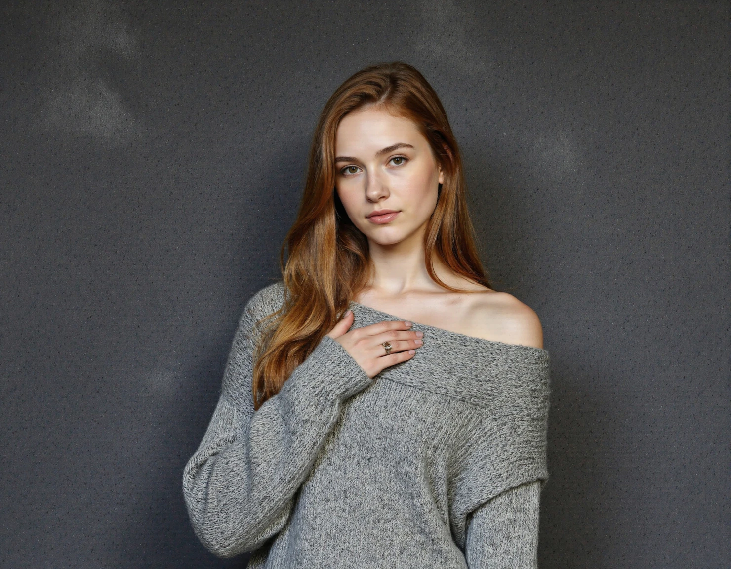 Young woman in gray sweater posing with hand on chest #40219
