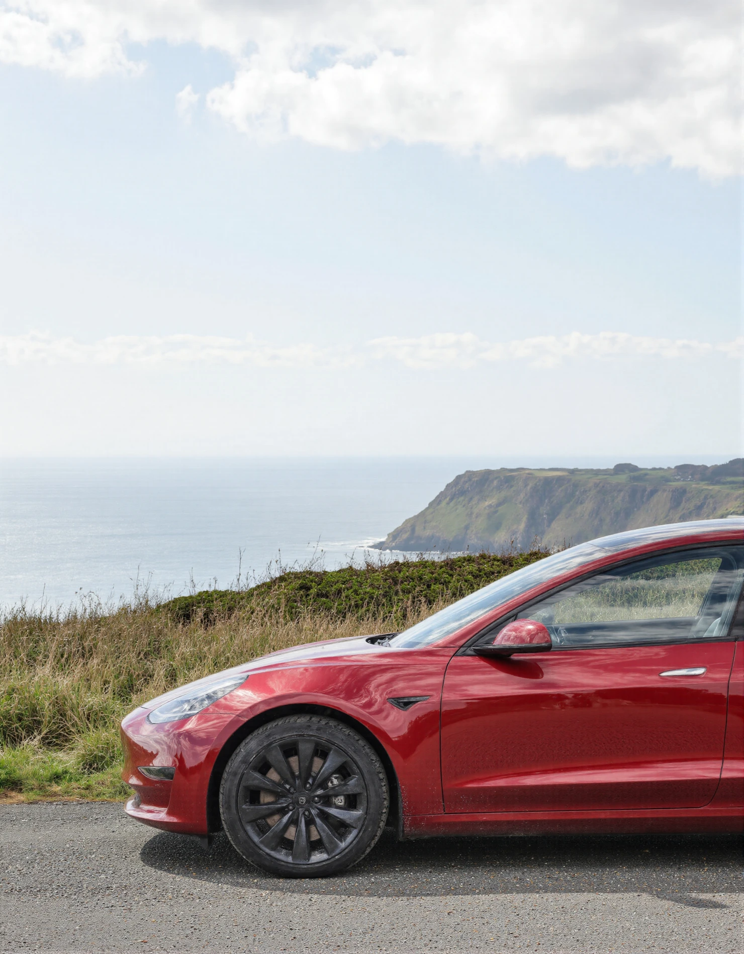 Red Tesla Model 3 on a Scenic Coastal Road with Ocean View #40855