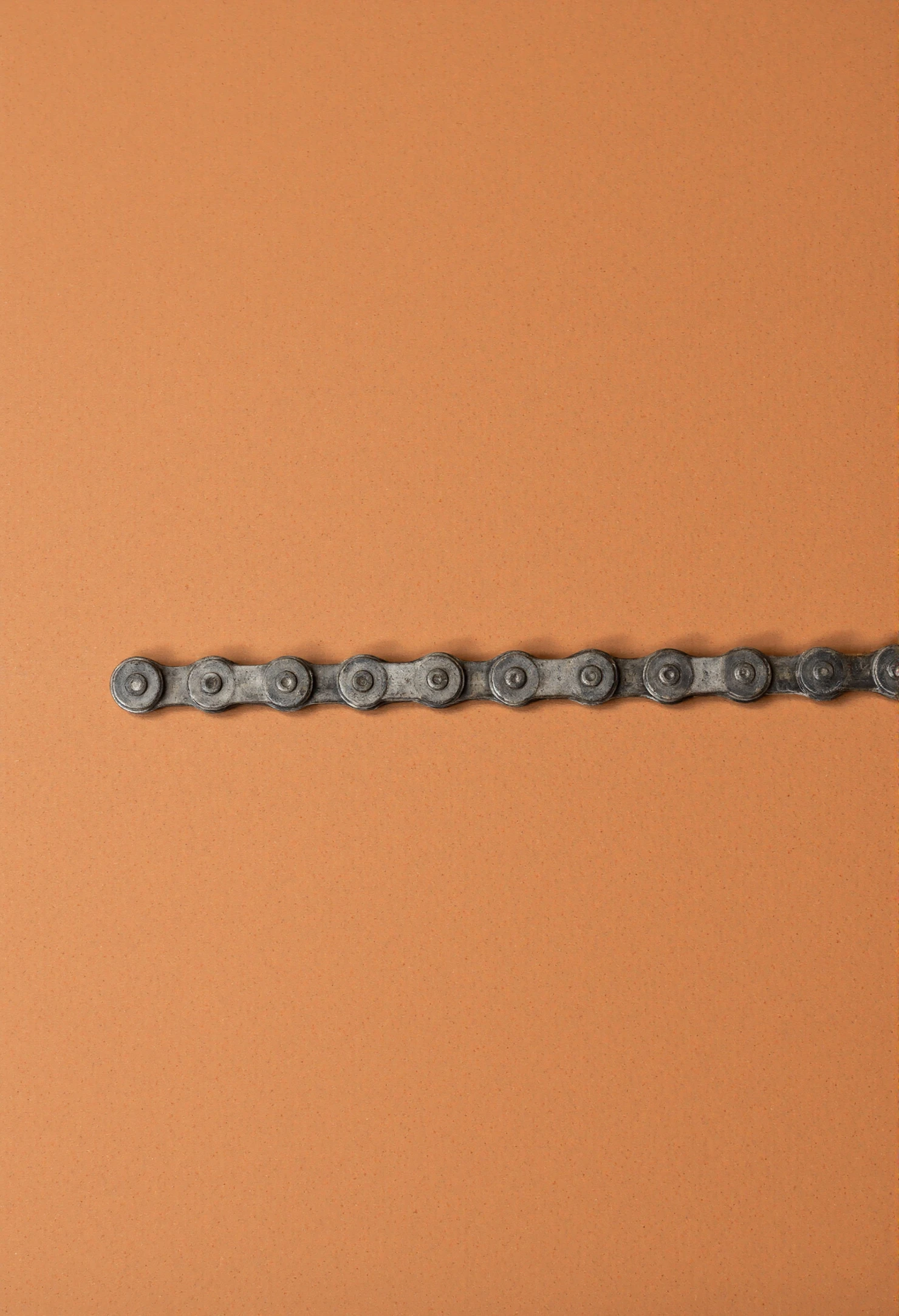 Bicycle Chain Segment on a Plain Orange Background #40979