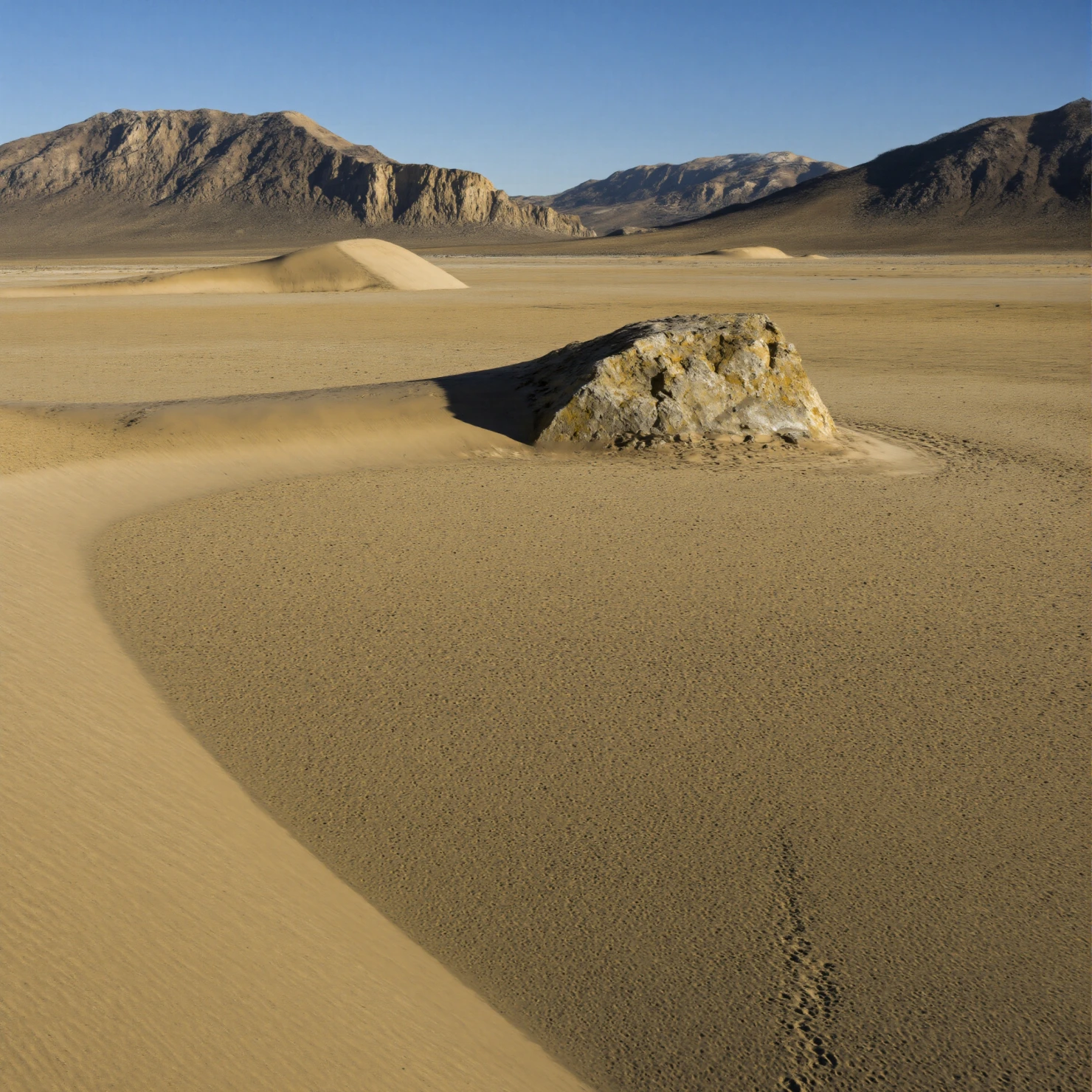 Vast Arid Playa with Rock Outcrop and Distant Mountains #41203
