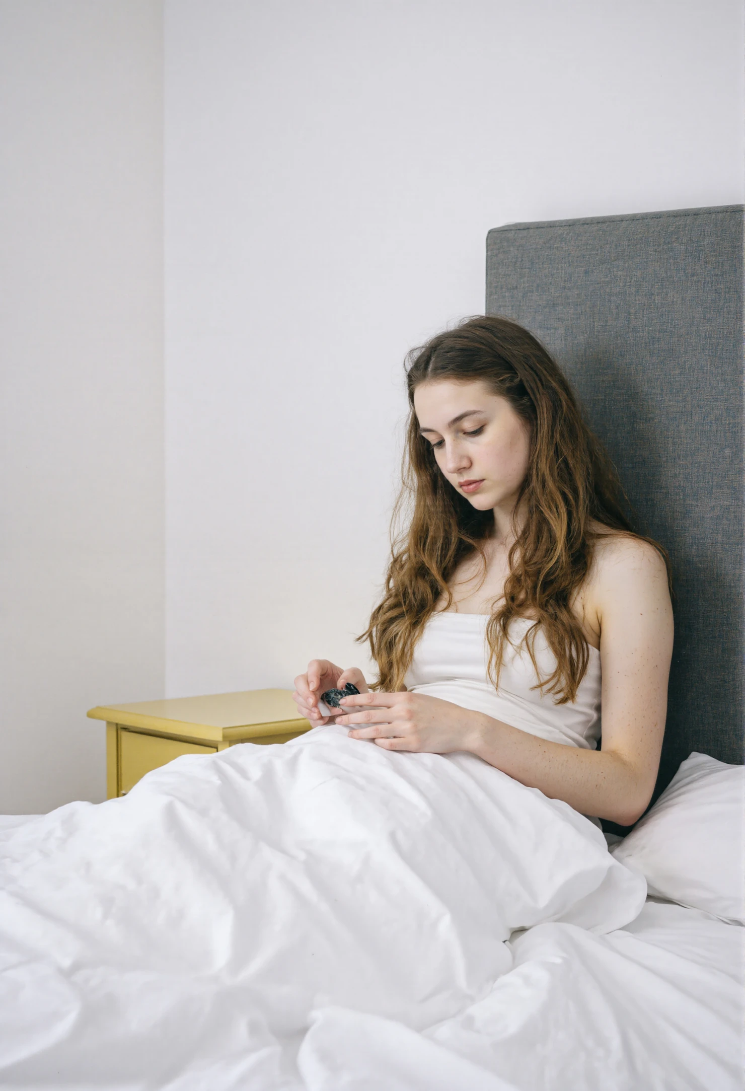 Young Woman Engaged with Device in Bed on a Quiet Morning #41237