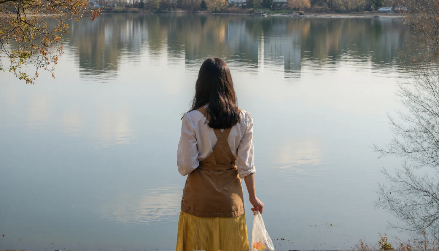 Woman standing by a tranquil lake, reflecting on the autumn day #41256